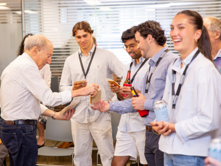 Diverse team of professionals and mentor sharing snacks and smiles at office celebration