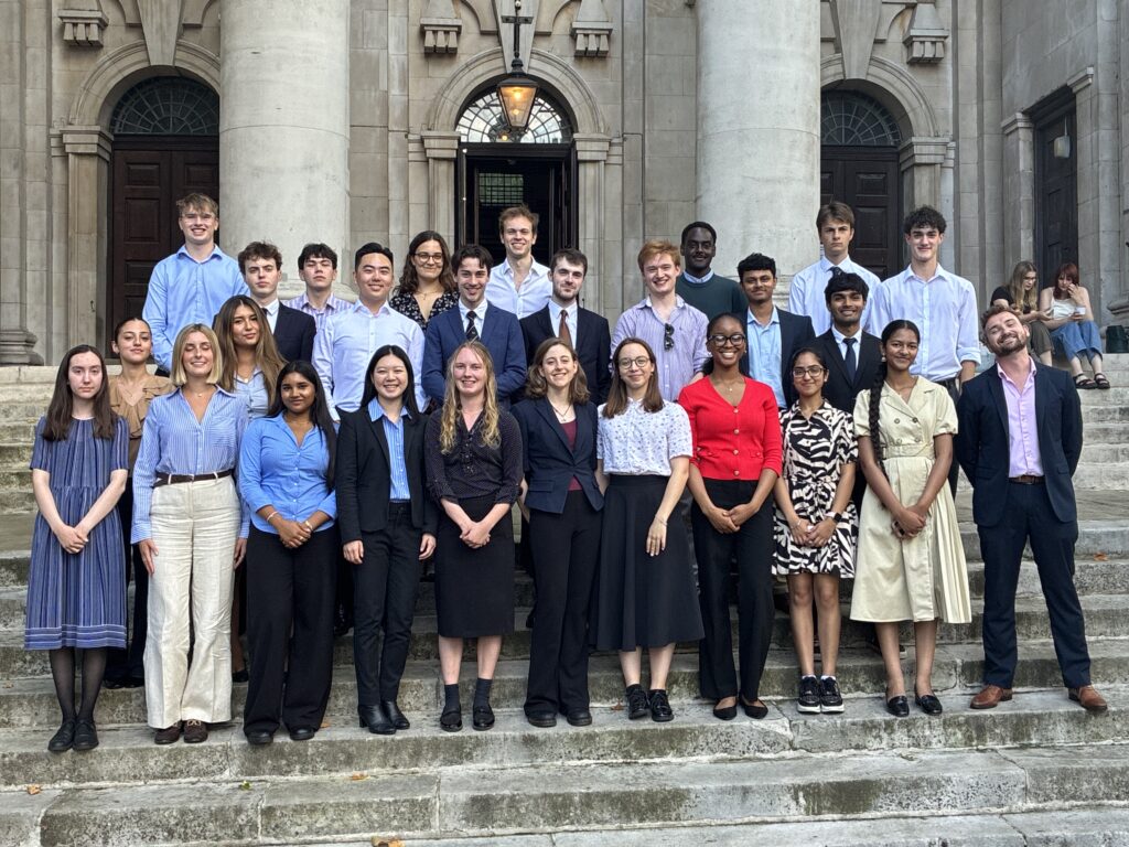 Large professional group photo of young adults in business clothes on classical building steps